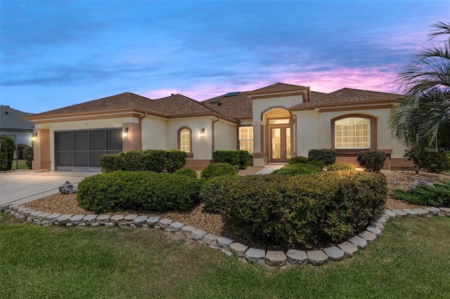 mediterranean / spanish house featuring a lawn and a garage