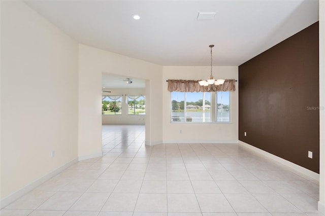 unfurnished room featuring a chandelier and light tile patterned flooring