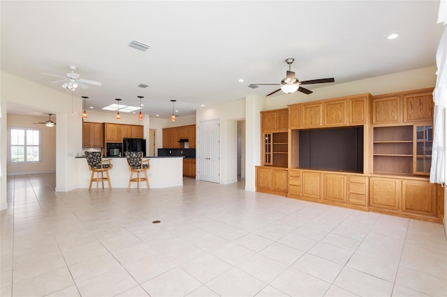 unfurnished living room featuring ceiling fan and light tile patterned flooring