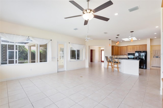 unfurnished living room featuring light tile patterned floors and ceiling fan