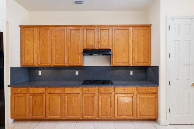 kitchen with light tile patterned flooring, gas stovetop, and tasteful backsplash