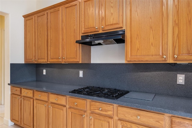 kitchen featuring tasteful backsplash, gas stovetop, and light tile patterned flooring