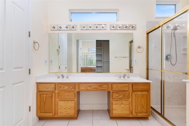 bathroom featuring tile patterned flooring, vanity, and walk in shower