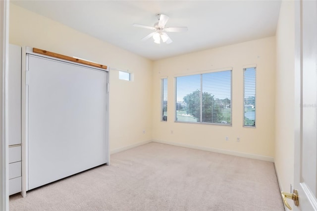 unfurnished bedroom featuring ceiling fan and light carpet