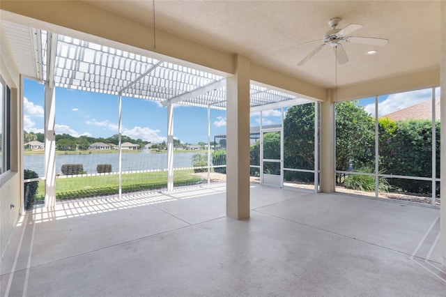 unfurnished sunroom with ceiling fan and a water view