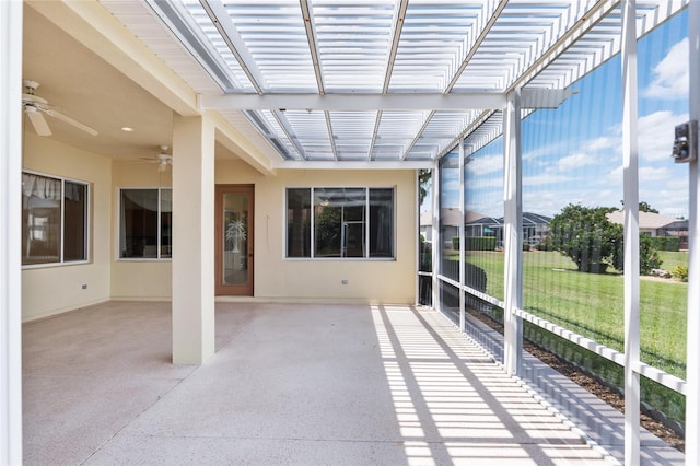 unfurnished sunroom with ceiling fan