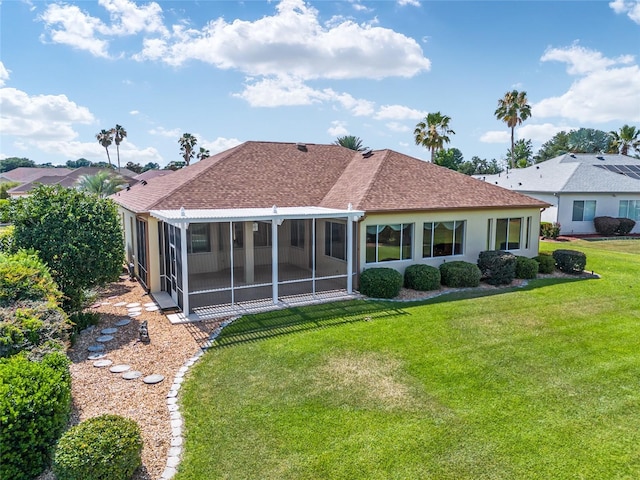 back of property with a sunroom, a pergola, and a lawn