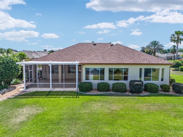 rear view of house featuring a lawn and a sunroom