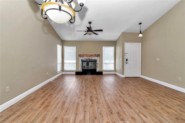 unfurnished living room with ceiling fan, a fireplace, and light wood-type flooring