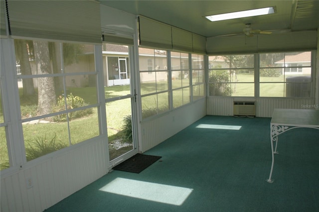 sunroom / solarium featuring an AC wall unit and ceiling fan