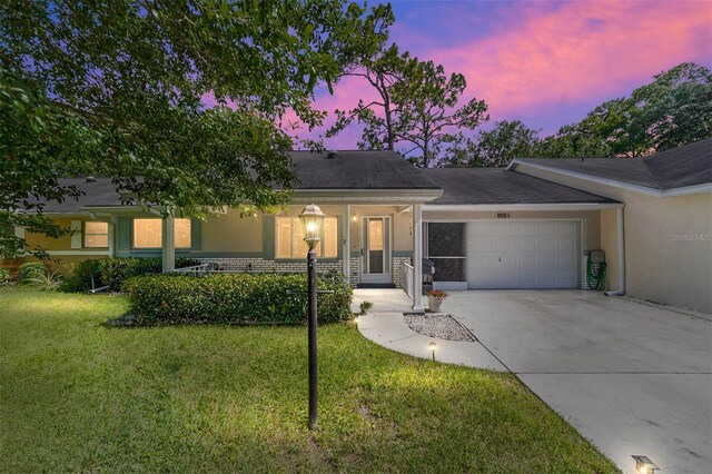 single story home with a garage and a yard