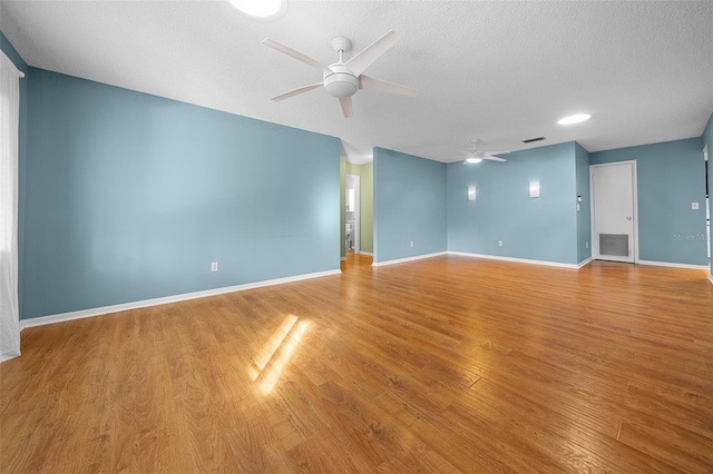 unfurnished room featuring light wood-type flooring, ceiling fan, visible vents, and baseboards