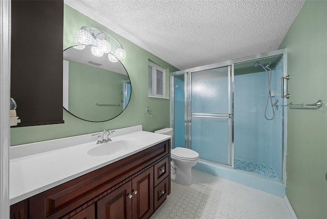 full bathroom with a textured ceiling, a stall shower, and vanity