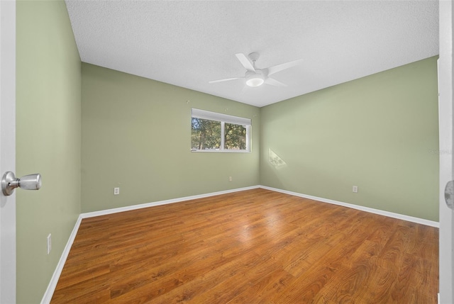 unfurnished room featuring ceiling fan, a textured ceiling, wood finished floors, and baseboards