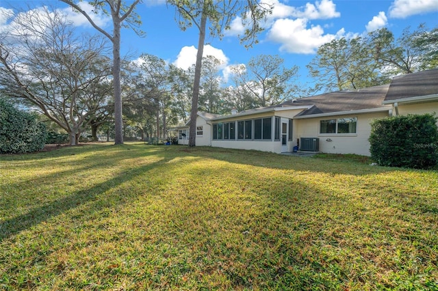 view of yard with a sunroom and central AC unit