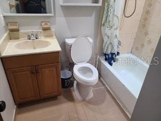 full bathroom featuring tile flooring, toilet, shower / bath combo, and vanity with extensive cabinet space