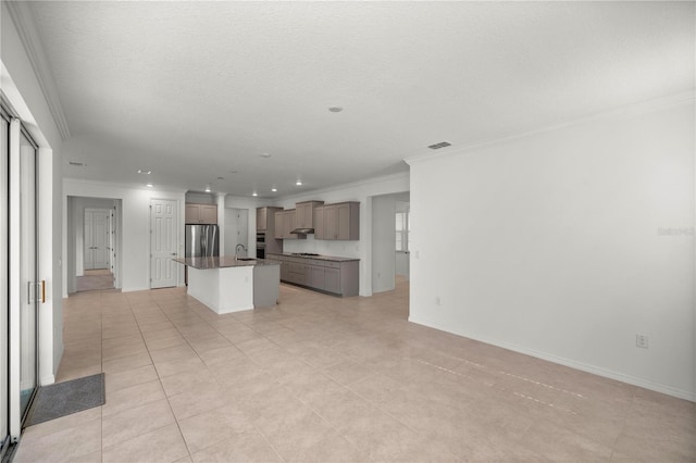 kitchen with stainless steel refrigerator, a kitchen island with sink, sink, and crown molding