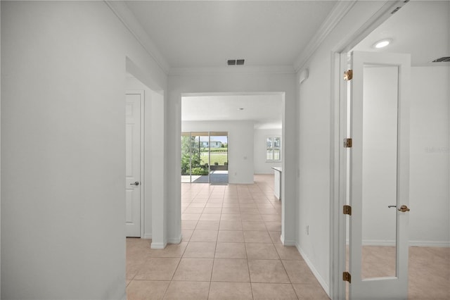 hall with light tile patterned floors and crown molding