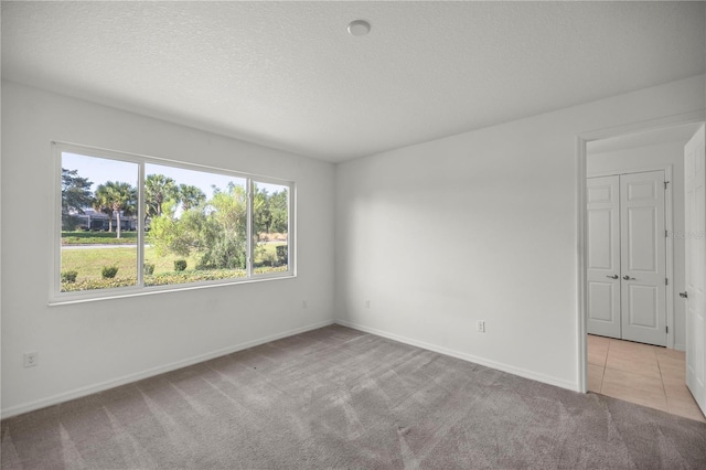 carpeted empty room with a textured ceiling and plenty of natural light