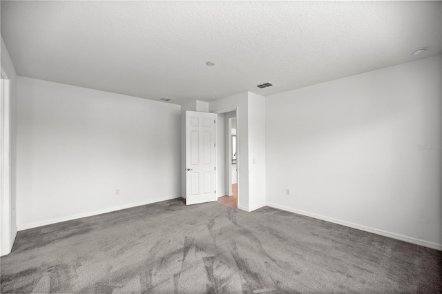 carpeted spare room featuring a textured ceiling