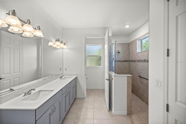 bathroom featuring tile patterned floors, vanity, and a tile shower