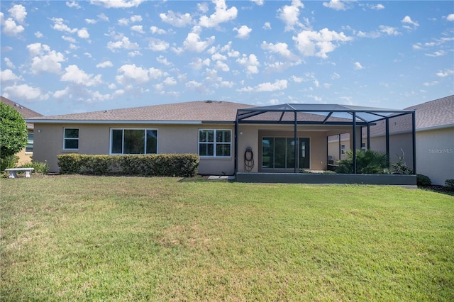 back of house with glass enclosure and a yard