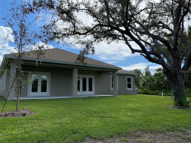 rear view of house featuring a lawn and french doors