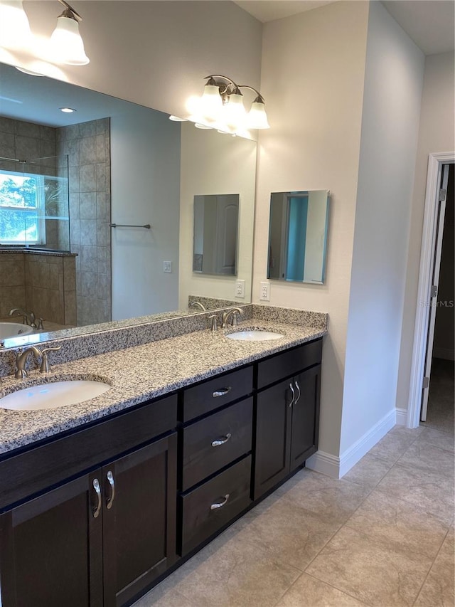 bathroom with tile patterned floors, vanity, and tiled shower