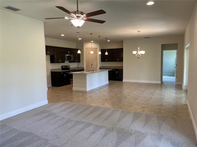 kitchen featuring sink, light colored carpet, stainless steel appliances, and a center island with sink