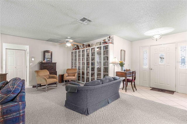 living room featuring tile patterned floors, ceiling fan, and a textured ceiling