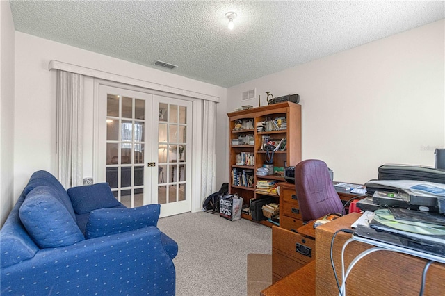 office with french doors, carpet, and a textured ceiling