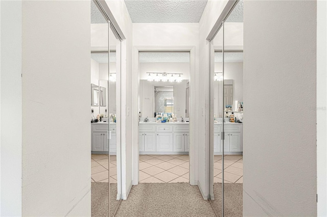 hall with sink and a textured ceiling