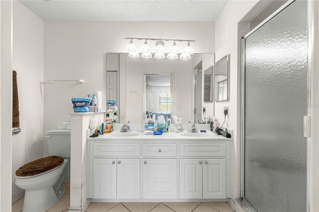 bathroom with tile patterned floors, a textured ceiling, toilet, vanity, and a shower with shower door