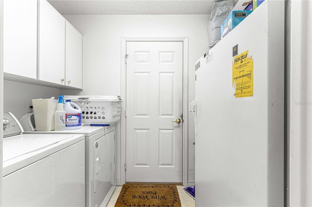 laundry area featuring cabinets, light tile patterned flooring, washing machine and dryer, and a textured ceiling