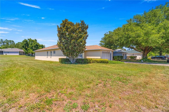 view of front of home with a garage and a front lawn