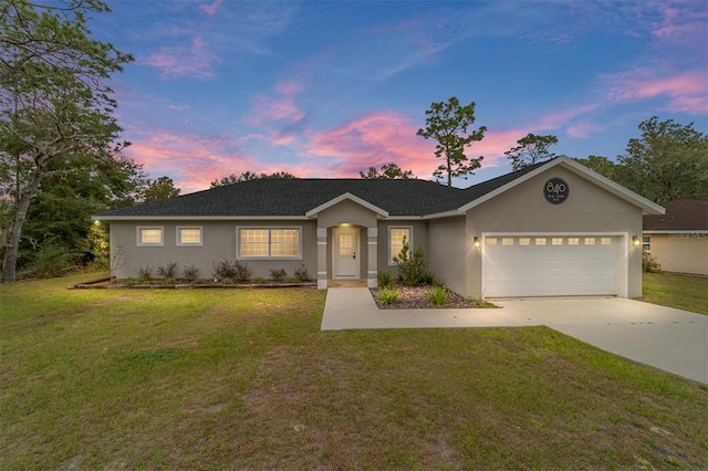 ranch-style home featuring a garage and a yard