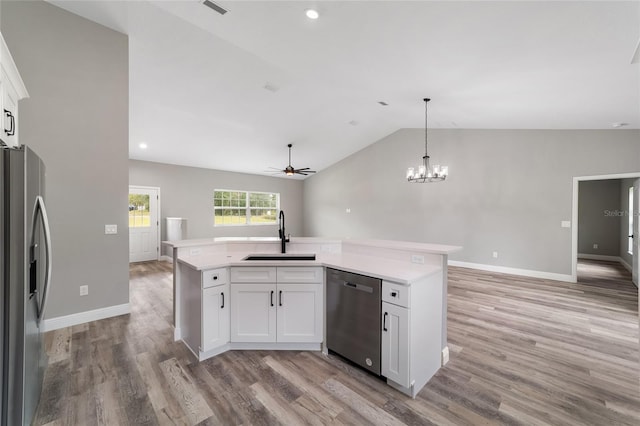 kitchen with white cabinetry, appliances with stainless steel finishes, sink, vaulted ceiling, and light hardwood / wood-style flooring