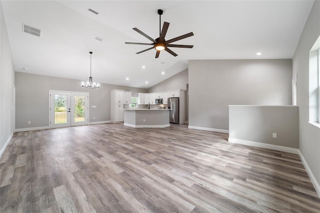 unfurnished living room featuring french doors, light hardwood / wood-style flooring, high vaulted ceiling, and ceiling fan with notable chandelier