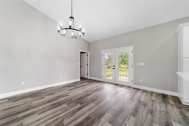 spare room with hardwood / wood-style floors, french doors, a chandelier, and high vaulted ceiling