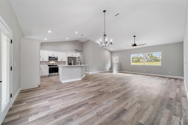 kitchen with stainless steel appliances, a kitchen island with sink, white cabinetry, light hardwood / wood-style flooring, and decorative light fixtures