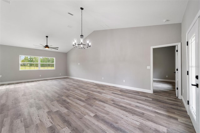 spare room with light wood-type flooring, lofted ceiling, and ceiling fan with notable chandelier