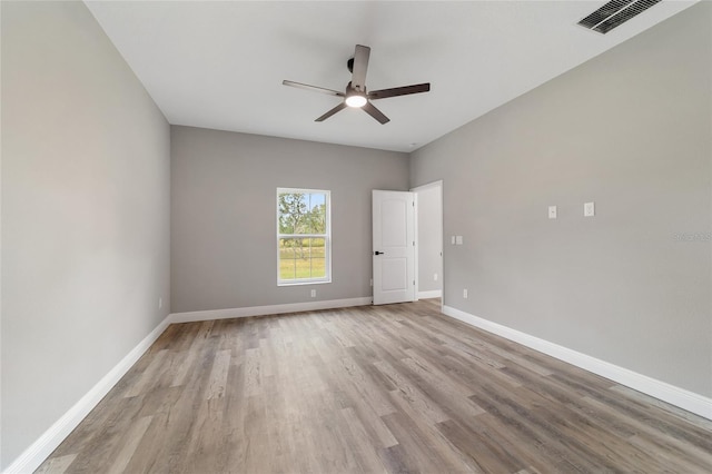 empty room with ceiling fan and light hardwood / wood-style flooring