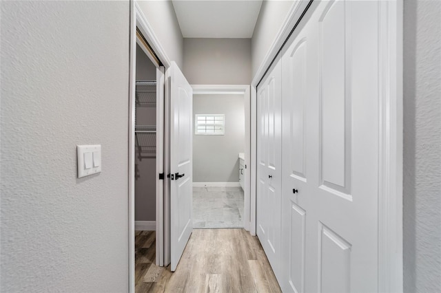 corridor with light hardwood / wood-style flooring