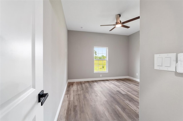 empty room with ceiling fan and light hardwood / wood-style flooring