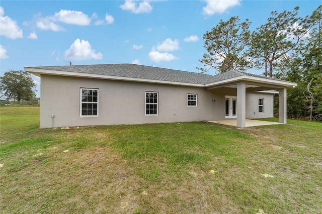 rear view of property featuring french doors, a lawn, and a patio