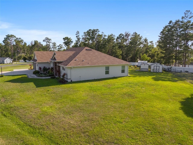 view of side of property with a storage shed and a yard