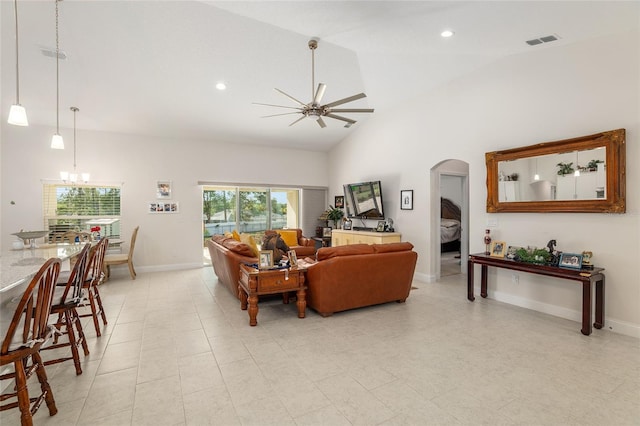 living room featuring ceiling fan with notable chandelier and high vaulted ceiling