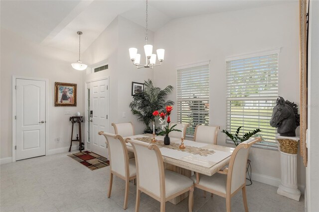 dining area featuring high vaulted ceiling and a chandelier