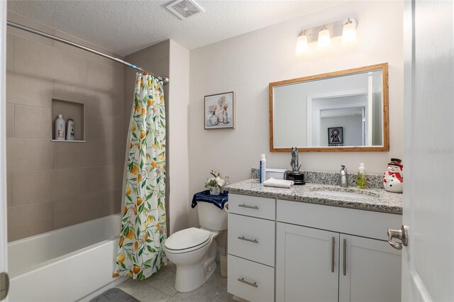 full bathroom featuring tile patterned floors, vanity, a textured ceiling, shower / bath combo with shower curtain, and toilet