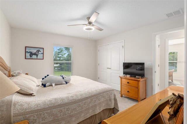 bedroom with multiple windows, a closet, and ceiling fan